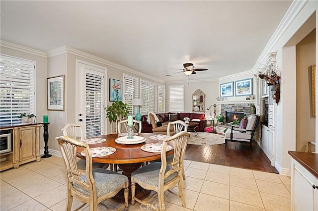 37557 Windsor Ct, Murrieta, CA 92562 - dining space featuring light tile patterned flooring, a fireplace, crown molding, and a ceiling fan