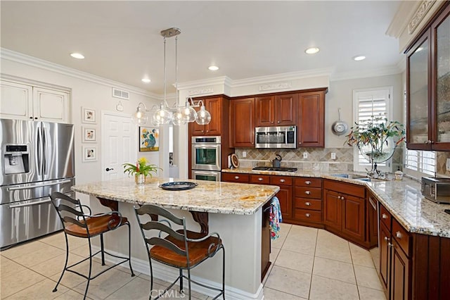 37557 Windsor Ct, Murrieta, CA 92562 - kitchen featuring decorative backsplash, visible vents, a kitchen bar, stainless steel appliances, and a kitchen island