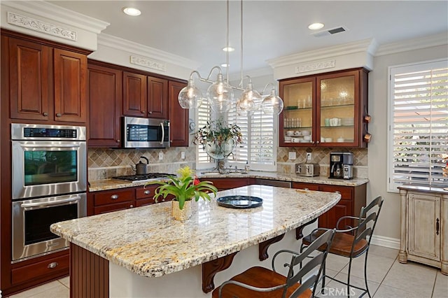 37557 Windsor Ct, Murrieta, CA 92562 - kitchen featuring a center island, ornamental molding, a kitchen breakfast bar, and appliances with stainless steel finishes