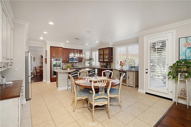 37557 Windsor Ct, Murrieta, CA 92562 - dining space with light tile patterned floors, crown molding, baseboards, and recessed lighting