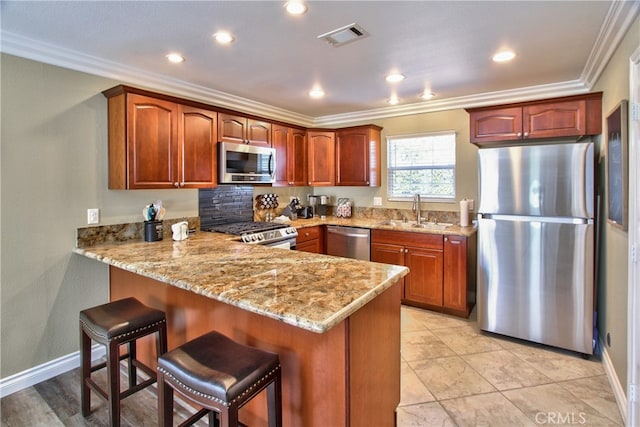 41548 Hutchison Ct, Murrieta, CA 92562 - kitchen with appliances with stainless steel finishes, a sink, crown molding, a peninsula, and light stone countertops