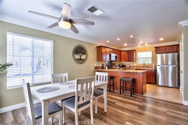 41548 Hutchison Ct, Murrieta, CA 92562 - dining room with ornamental molding, a ceiling fan, recessed lighting, light wood-type flooring, and baseboards