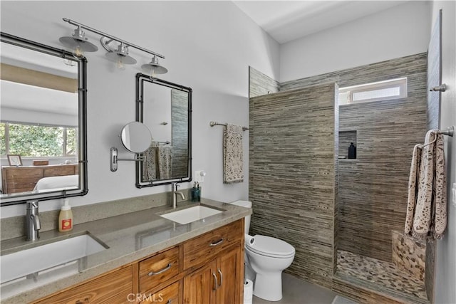 full bath featuring toilet, a tile shower, and a sink