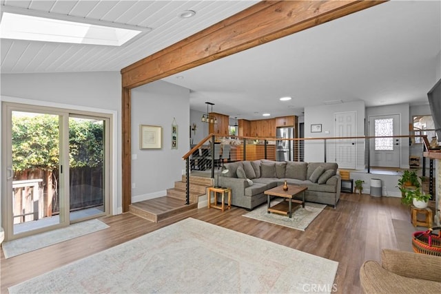 living room with wood finished floors, baseboards, stairway, vaulted ceiling with beams, and recessed lighting