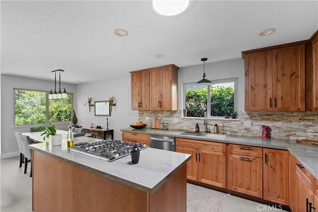 kitchen featuring stainless steel appliances, a healthy amount of sunlight, a sink, and tasteful backsplash