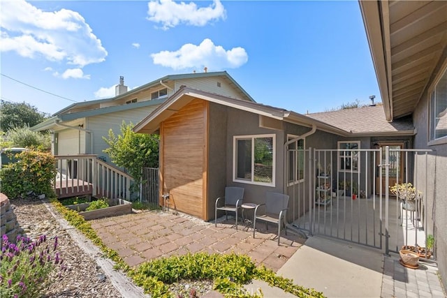 back of property featuring a patio, fence, and a gate