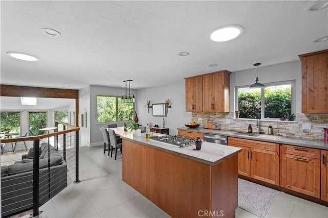 kitchen featuring appliances with stainless steel finishes, decorative backsplash, brown cabinetry, and a kitchen island