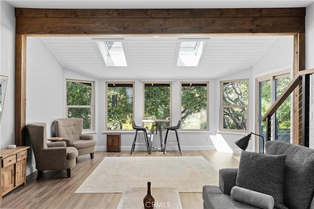 interior space featuring baseboards, wood finished floors, and lofted ceiling with skylight