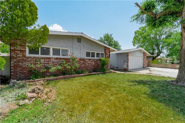 44546 E 3rd St E, Lancaster, CA 93535 - view of front facade with an outbuilding, brick siding, a front lawn, concrete driveway, and a detached garage