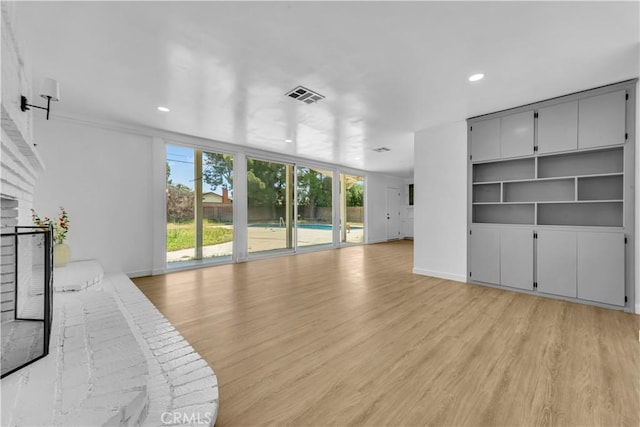 44546 E 3rd St E, Lancaster, CA 93535 - unfurnished living room with plenty of natural light, light wood-style flooring, a brick fireplace, recessed lighting, and baseboards