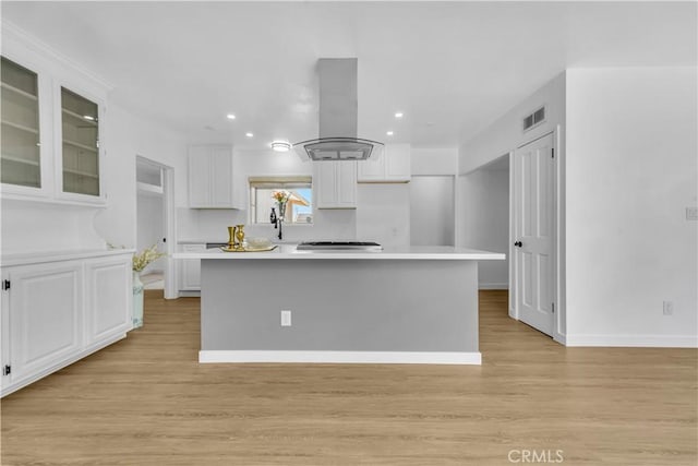 44546 E 3rd St E, Lancaster, CA 93535 - kitchen featuring island exhaust hood, white cabinets, light wood-style floors, and recessed lighting