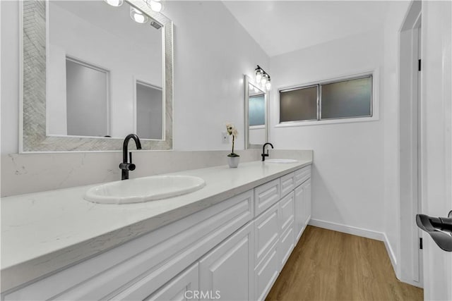44546 E 3rd St E, Lancaster, CA 93535 - bathroom featuring wood finished floors, double vanity, and baseboards