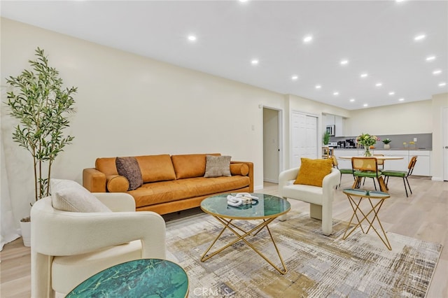 living area with light wood-style flooring and recessed lighting