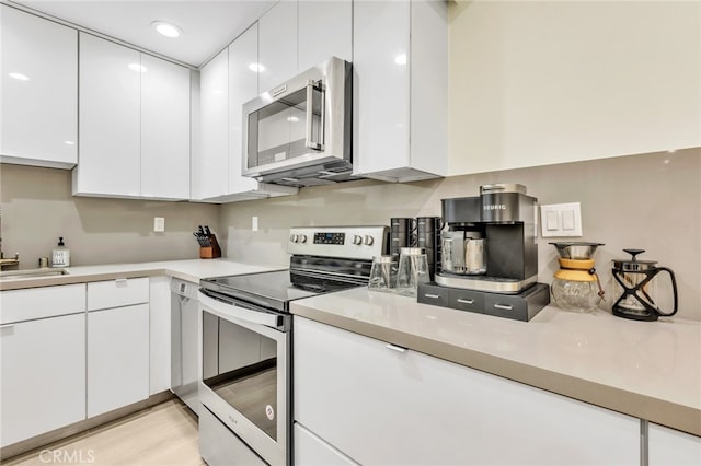 kitchen featuring white cabinetry, light countertops, and appliances with stainless steel finishes