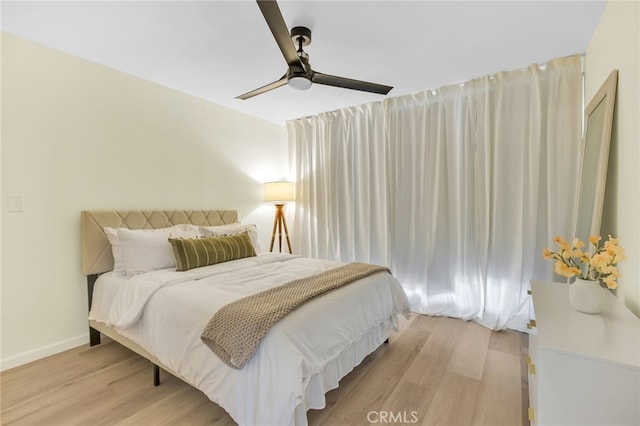 bedroom featuring light wood-style flooring, baseboards, and ceiling fan