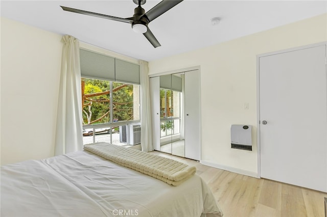 bedroom with cooling unit, ceiling fan, wood finished floors, and a closet