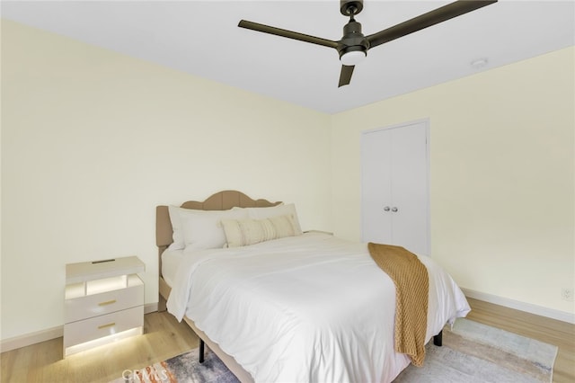 bedroom with baseboards, a ceiling fan, and light wood finished floors