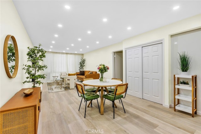 dining space with light wood finished floors and recessed lighting