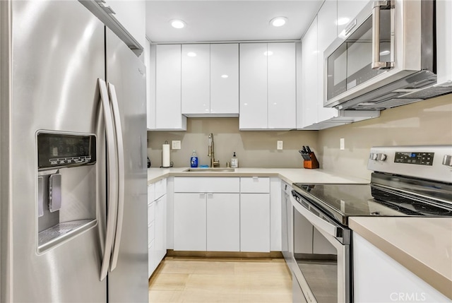 kitchen featuring light countertops, white cabinets, a sink, and appliances with stainless steel finishes