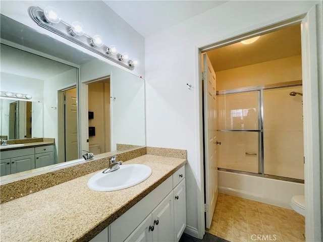 bathroom with toilet, vanity, and shower / bath combination with glass door