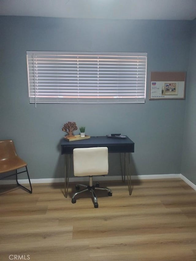 home office with baseboards and wood finished floors