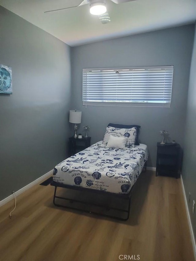 bedroom featuring wood finished floors, ceiling fan, and baseboards