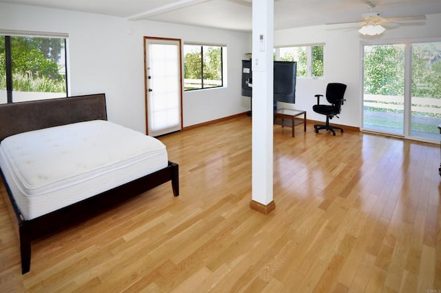 bedroom with light wood-style flooring, baseboards, multiple windows, and a ceiling fan