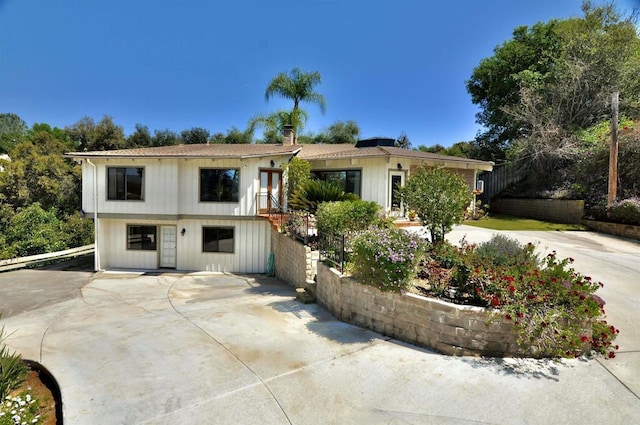 view of front of house with fence and concrete driveway