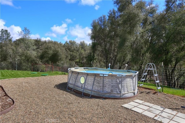 view of yard with an outdoor pool and fence