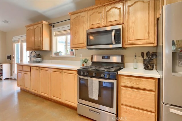 kitchen featuring light countertops, light brown cabinets, appliances with stainless steel finishes, and visible vents