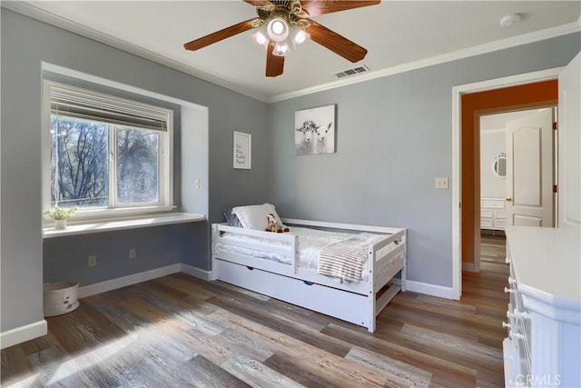 bedroom with baseboards, ornamental molding, and wood finished floors