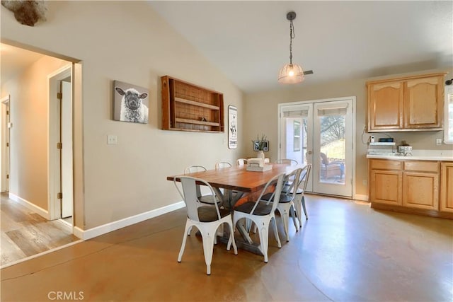 dining room featuring baseboards, lofted ceiling, french doors, and concrete floors