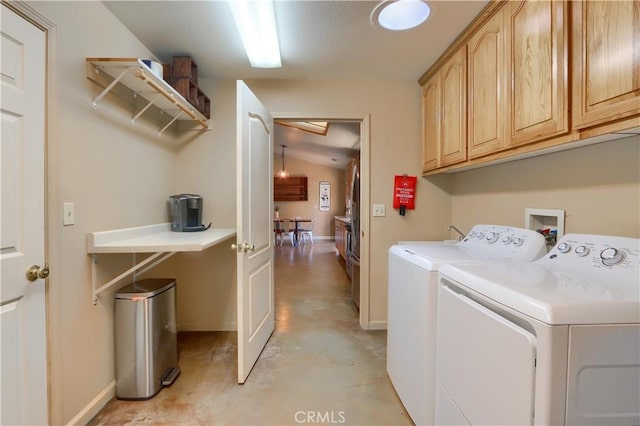 clothes washing area featuring cabinet space, baseboards, and washer and clothes dryer