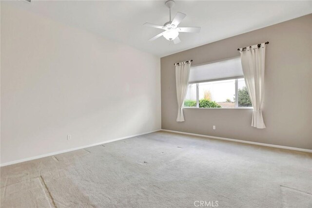 empty room featuring baseboards, carpet flooring, and a ceiling fan