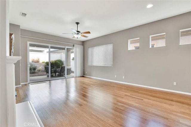 empty room with baseboards, visible vents, a ceiling fan, and wood finished floors
