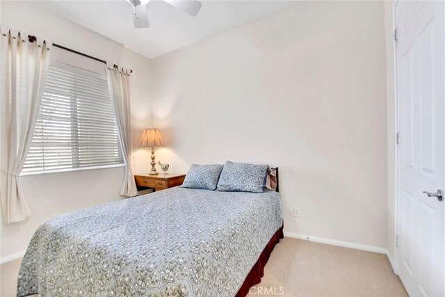 carpeted bedroom featuring baseboards and ceiling fan