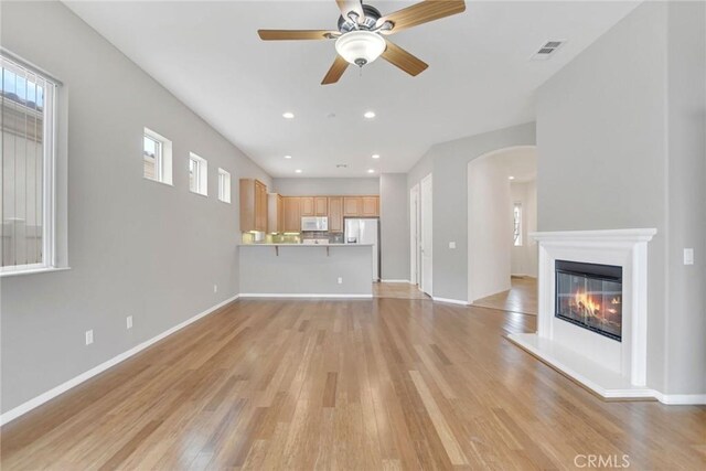 unfurnished living room with visible vents, light wood finished floors, baseboards, ceiling fan, and recessed lighting