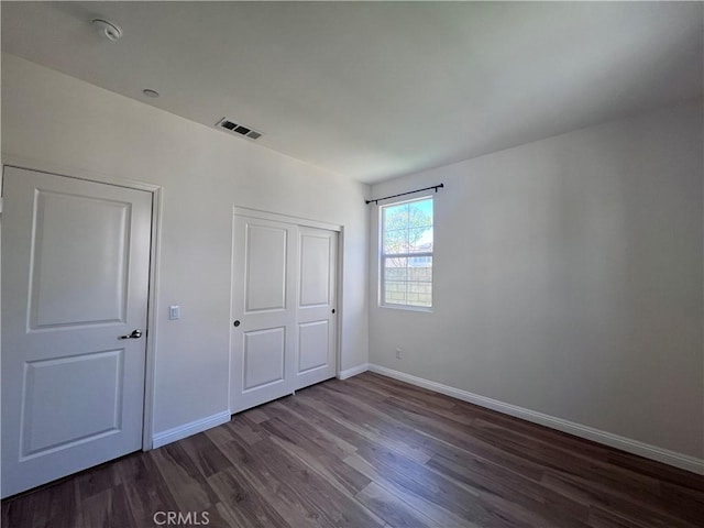 2866 S Via Belamaria, Ontario, CA 91762 - unfurnished bedroom with baseboards, dark wood-type flooring, visible vents, and a closet