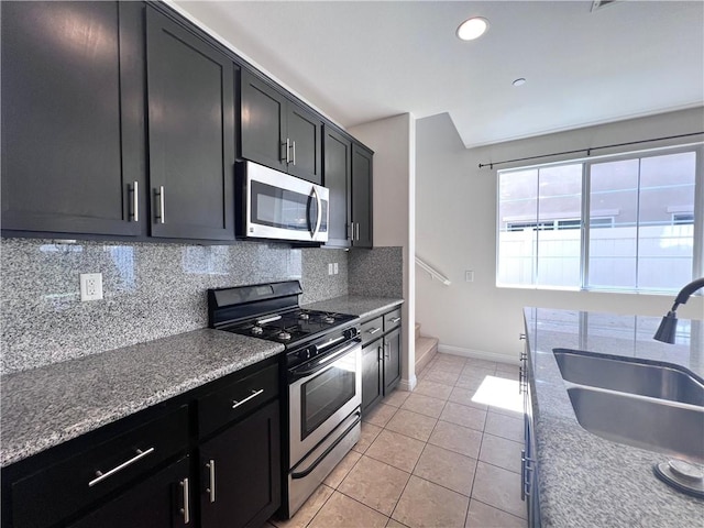 2866 S Via Belamaria, Ontario, CA 91762 - kitchen featuring dark cabinetry, a sink, appliances with stainless steel finishes, and tasteful backsplash
