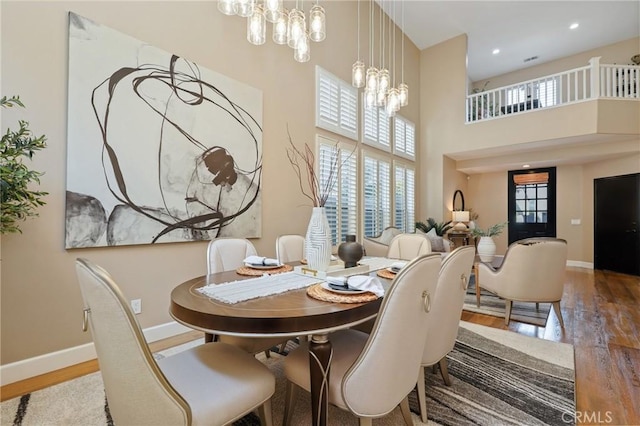 dining space with an inviting chandelier, baseboards, and wood finished floors