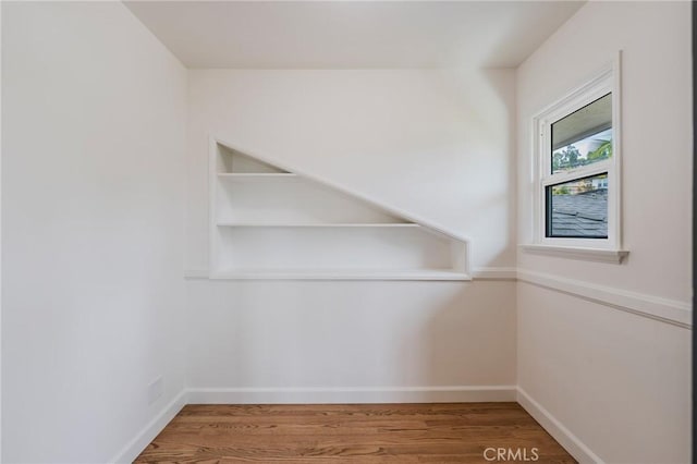 interior space featuring baseboards and wood finished floors