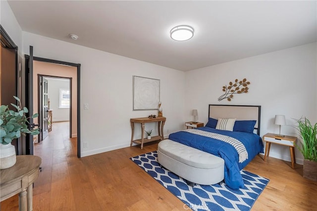 bedroom featuring baseboards and wood finished floors