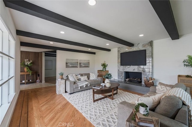 living room featuring wood finished floors, recessed lighting, beam ceiling, and a fireplace