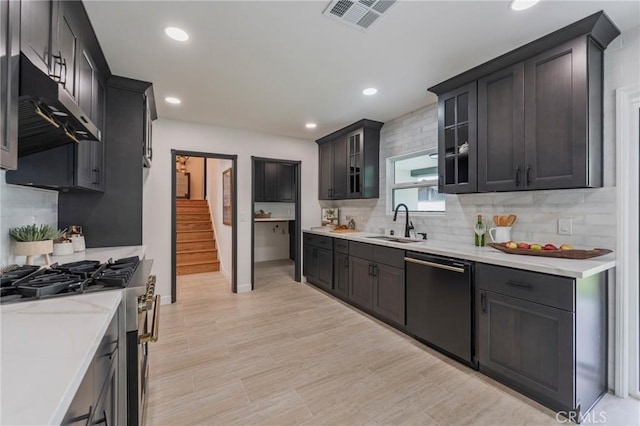 kitchen featuring a sink, gas stove, black dishwasher, under cabinet range hood, and visible vents