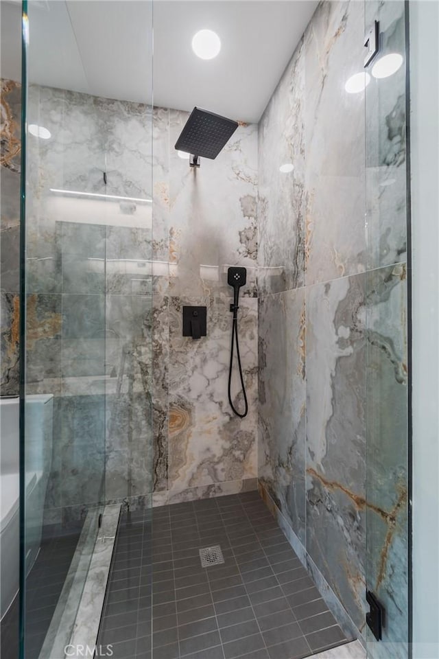 bathroom with a marble finish shower and tile patterned floors
