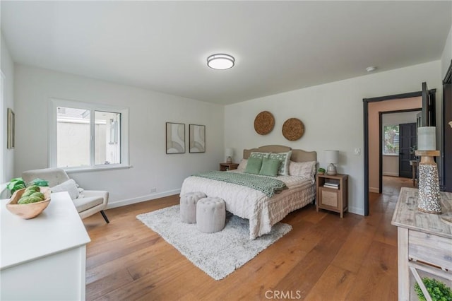 bedroom with baseboards and wood finished floors