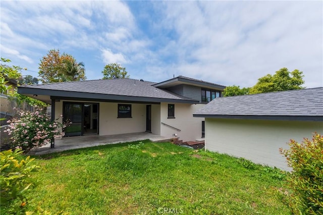 rear view of house featuring a shingled roof, a patio area, fence, and a yard