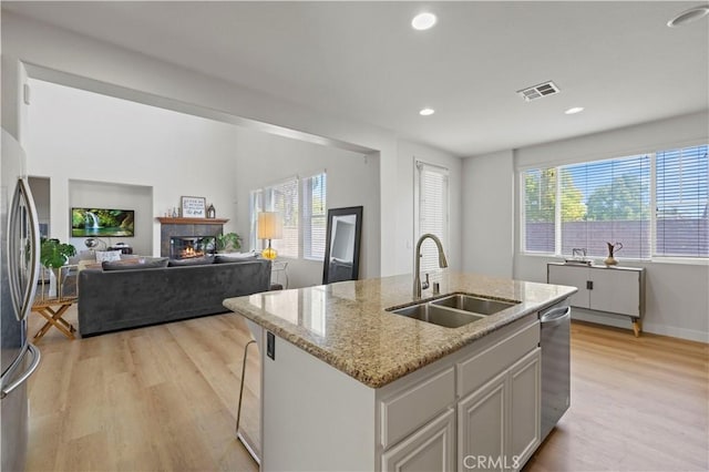 32177 Clear Springs Dr, Winchester, CA 92596 - kitchen with stainless steel appliances, light wood finished floors, light stone counters, a center island with sink, and recessed lighting
