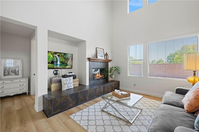 32177 Clear Springs Dr, Winchester, CA 92596 - living room featuring wood finished floors, a tiled fireplace, and a towering ceiling