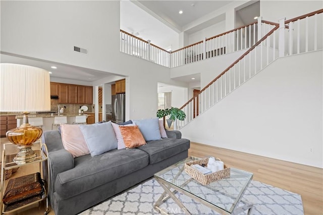 32177 Clear Springs Dr, Winchester, CA 92596 - living area with light wood-style flooring, a high ceiling, stairway, and recessed lighting